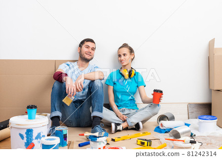 Happy boy and girl drinking coffee on floor. 81242314