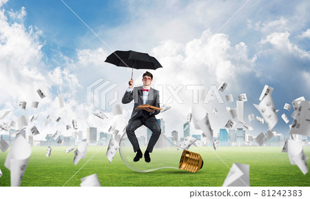 young businessman with an umbrella and a book young businessman with an umbrella and a book 81242383