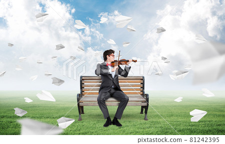 Young businessman plays the violin Young businessman plays the violin 81242395