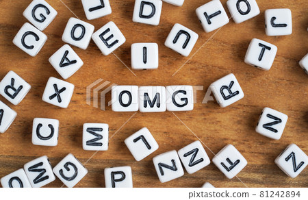 Small white and black bead cubes on wooden board, letters in middle spell OMG 81242894