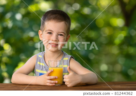 little boy with glass of juice and showing thumbs up little boy with glass of juice and showing thumbs up 81244362