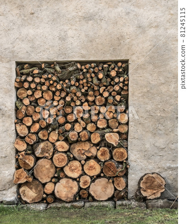 A pile of woods in the house storage. Raw barked wood logs in a storage yard. 81245115