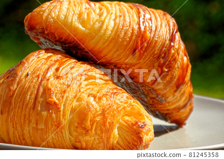 Close-up with fresh golden croissants on a plate 81245358