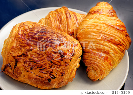 Fresh croissants and pain au chocolate on a plate Fresh croissants and pain au chocolate on a plate 81245399