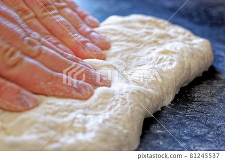 Close-up view of professional baker preparing bread dough in a kitchen 81245537