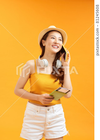 Happy woman speaks on the phone holding passport. Happy woman speaks on the phone holding passport. 81245608