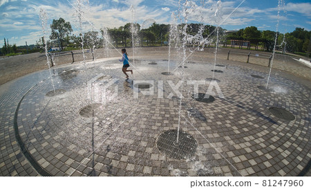 A child playing happily at the water playground in the summer park 81247960