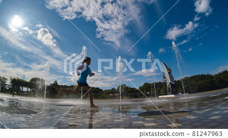 A child playing happily at the water playground in the summer park 81247963