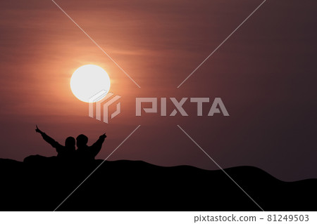 silhouette of man and woman on the mountain with sunset in the evening. silhouette of man and woman on the mountain with sunset in the evening. 81249503