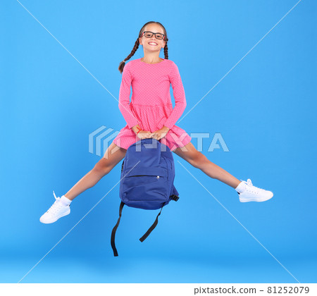 Energetic happy schoolgirl in eyewear with funny surprised facial expression jumping up in air Energetic happy schoolgirl in eyewear with funny surprised facial expression jumping up in air 81252079
