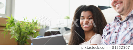 Man and woman are sitting on floor and looking at laptop Man and woman are sitting on floor and looking at laptop 81252507