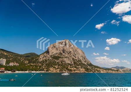 The Republic of Crimea. July 15, 2021. Picturesque view in sunny weather of Mount Sokol in the village of Novy Svet from the side of the Golitsyn trail through Zelenaya Bay. The Republic of Crimea. July 15, 2021. Picturesque view in sunny weather of Mount Sokol in the village of Novy Svet from the side of the Golitsyn trail through Zelenaya Bay. 81252524