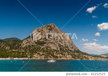 The Republic of Crimea. July 15, 2021. Picturesque view in sunny weather of Mount Sokol in the village of Novy Svet from the side of the Golitsyn trail through Zelenaya Bay. The Republic of Crimea. July 15, 2021. Picturesque view in sunny weather of Mount Sokol in the village of Novy Svet from the side of the Golitsyn trail through Zelenaya Bay. 81252525