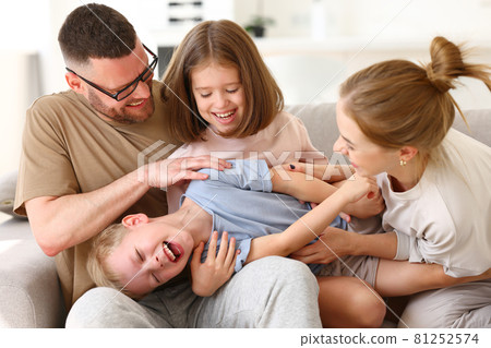 Happy beautiful family having fun and playing while relaxing on sofa in living room 81252574