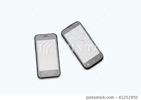 Two black phones lie on a white background. The broken smartphone. Cracks on the screen. Two black phones lie on a white background. The broken smartphone. Cracks on the screen. 81252950