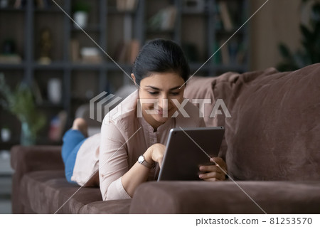 Happy Indian woman relax at home using pad 81253570