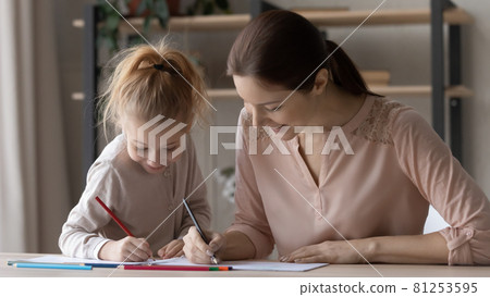 Smiling mom and small daughter drawing in album together 81253595
