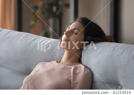 Closeup peaceful woman fall asleep leaned on comfy sofa cushion 81253614