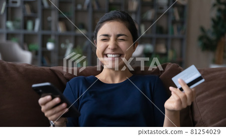 Smiling Indian female buyer shopping on cellphone Smiling Indian female buyer shopping on cellphone 81254029
