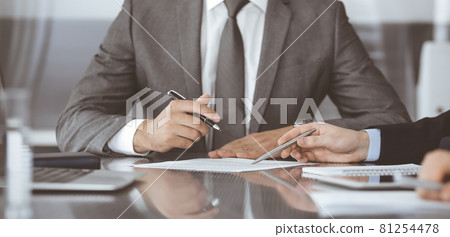 Unknown business people working together at meeting in modern office, close-up. Businessman and woman with colleagues or lawyers discussing contract at negotiation 81254478