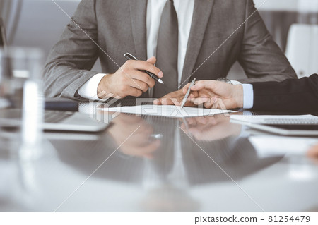 Unknown business people working together at meeting in modern office, close-up. Businessman and woman with colleagues or lawyers discussing contract at negotiation Unknown business people working together at meeting in modern office, close-up. Businessman and woman with colleagues or lawyers discussing contract at negotiation 81254479
