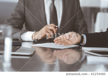 Unknown business people working together at meeting in modern office, close-up. Businessman and woman with colleagues or lawyers discussing contract at negotiation Unknown business people working together at meeting in modern office, close-up. Businessman and woman with colleagues or lawyers discussing contract at negotiation 81254480