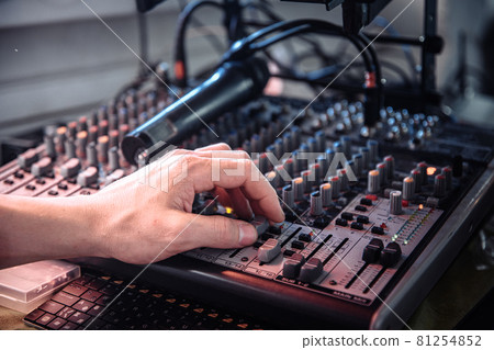 DJ's hand touching the audio control panel DJ's hand touching the audio control panel 81254852