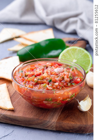 Tex-Mex cuisine salsa Asada sauce with roasted vegetables, served with tortilla chips and lime, vertical 81255612