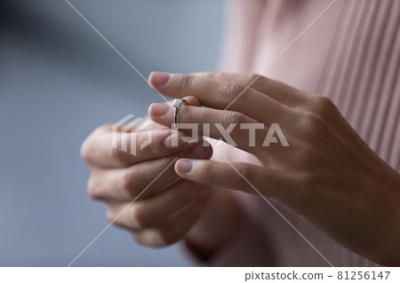 Young woman takes off wedding ring, close up view 81256147