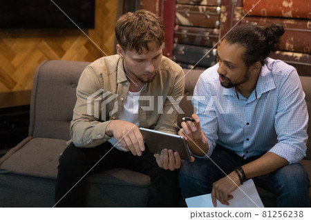 Multi ethnic teammates discussing collaborative project using digital tablet 81256238