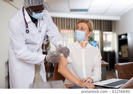 Young female office employee getting antiviral injection 81256680