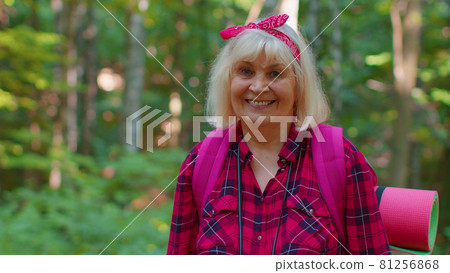 Senior grandmother tourist engaged in Nordic walking sport hiking with backpacks, trekking poles Senior grandmother tourist engaged in Nordic walking sport hiking with backpacks, trekking poles 81256868