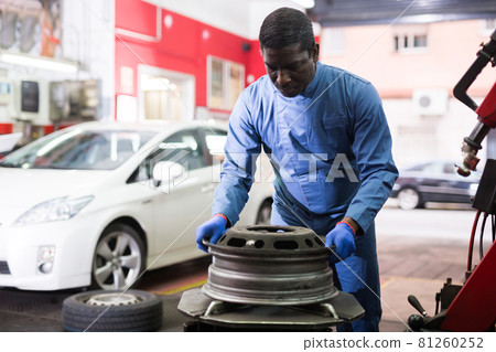 African american mechanic fixes car rims in car service African american mechanic fixes car rims in car service 81260252