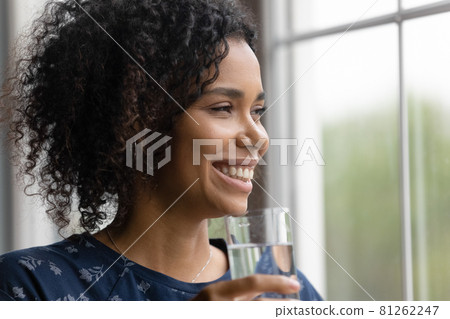 Happy millennial Black mixed race woman enjoying drinking fresh water 81262247