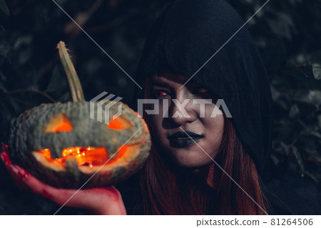 Portrait woman scary ghost in forest he has holding pumpkin Portrait woman scary ghost in forest he has holding pumpkin 81264506