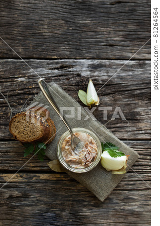 Stew in a glass jar and vegetables on a wooden table. 81264564