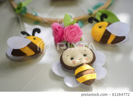 Cute bees and flowers handmade from felt material and plush with paddings. close up cot mobile hangings. Cute bees and flowers handmade from felt material and plush with paddings. close up cot mobile hangings. 81264772
