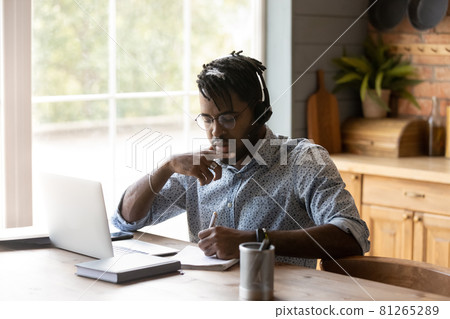 Focused African American student guy in headphones watching learning webinar 81265289