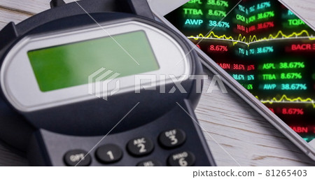 Image of financial data processing on smartphone next to payment terminal 81265403
