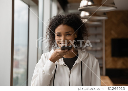 African female holding smart phone answers phone call on speakerphone 81266913