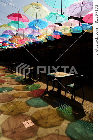 在冰見一班蓋的露台上，許多乙烯基雨傘和明亮的雨傘陰影的垂直組合，為藍天上色 81267173
