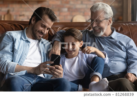 Smiling three generations of men use smartphone together Smiling three generations of men use smartphone together 81268839