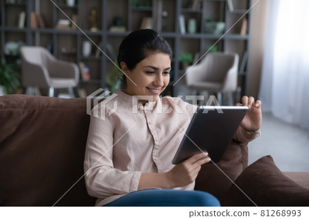 Smiling Indian woman use tablet at home Smiling Indian woman use tablet at home 81268993