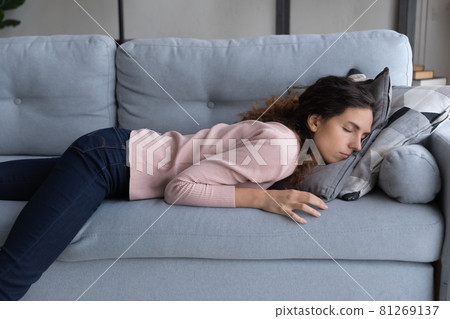Exhausted woman lying sleeping on sofa after sleepless night Exhausted woman lying sleeping on sofa after sleepless night 81269137