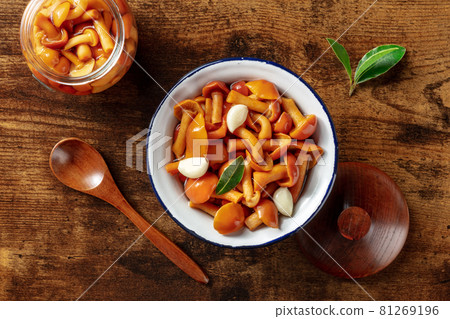 Pickled mushrooms with garlic and a bay leaf, overhead flat lay shot 81269196