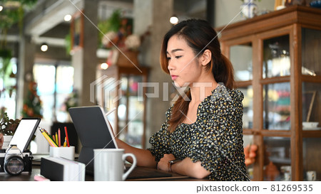 Side view of a photographer or creative designer is working with digital tablet at the office. Side view of a photographer or creative designer is working with digital tablet at the office. 81269535