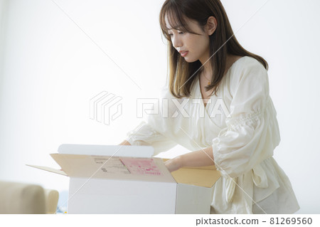 A woman who opens a luggage box 81269560