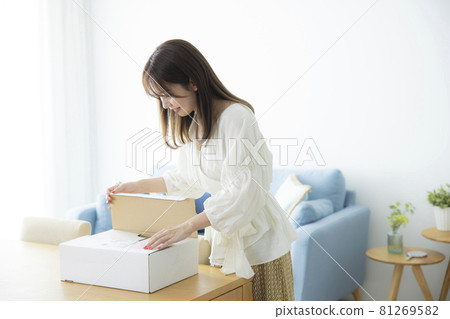 A woman who opens a luggage box 81269582