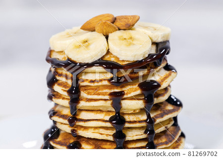 Pancakes with Chocolate Syrup, Nuts and Bananas. Stack of whole flapjack. Tasty breakfast and Healthy Food Pancakes with Chocolate Syrup, Nuts and Bananas. Stack of whole flapjack. Tasty breakfast and Healthy Food 81269702