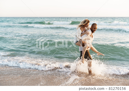 Young happy couple on seashore enjoying the sea 81270156